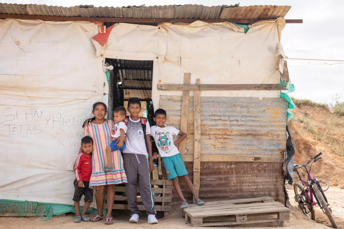 Juan David poses with his mother and three brothers at the front door of his house