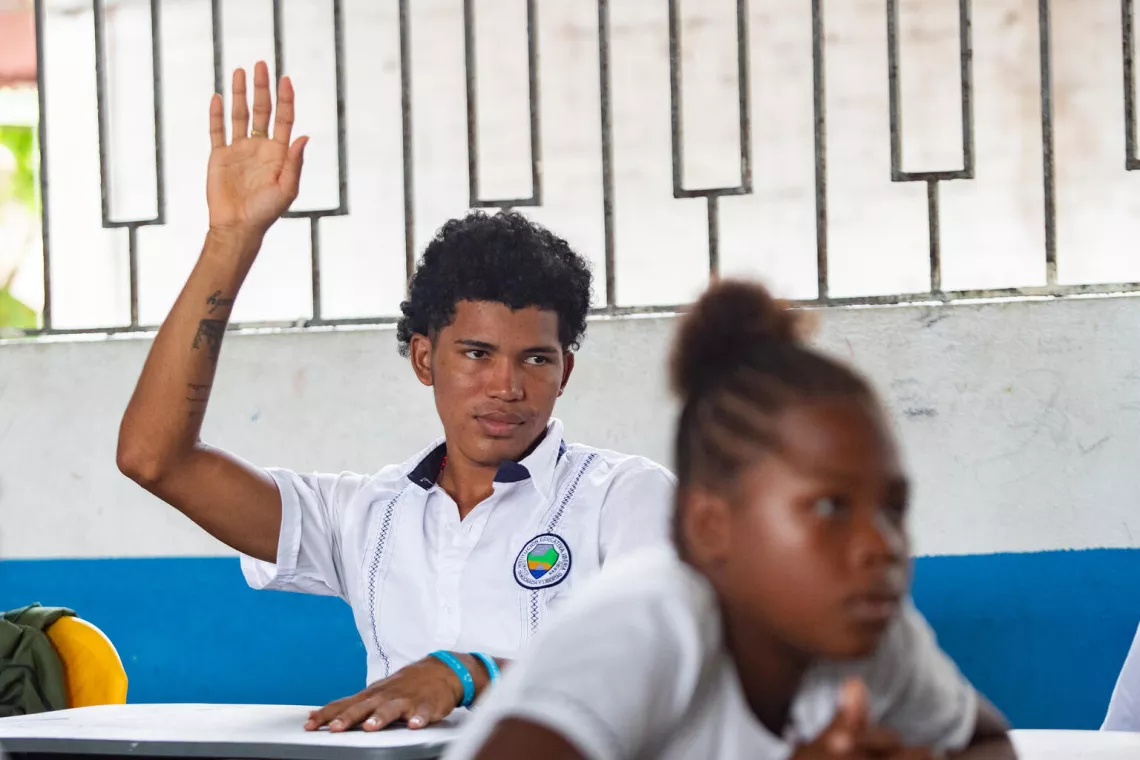 Josue raises his hand during class
