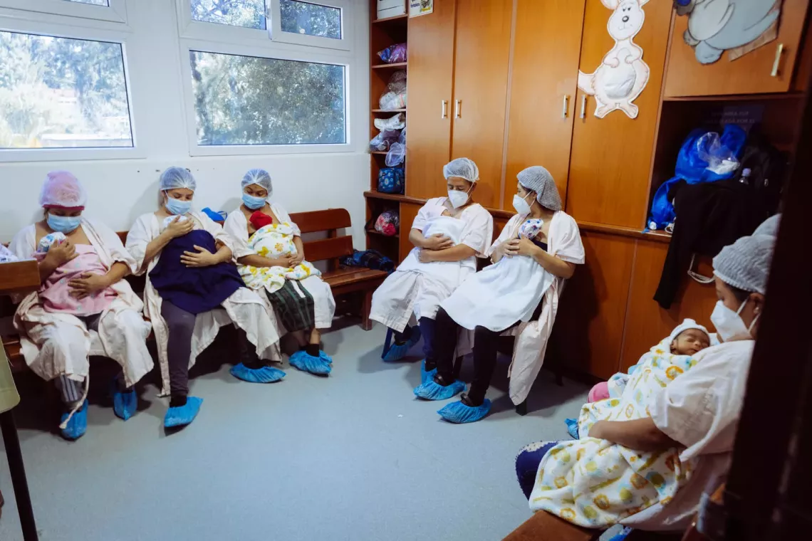Un grupo de madres y un padre sostienen a sus beb&eacute;s con el m&eacute;todo canguro 