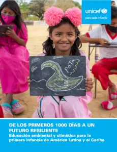Una nina se encuentra sentada sosteniendo un dibujo de un pato