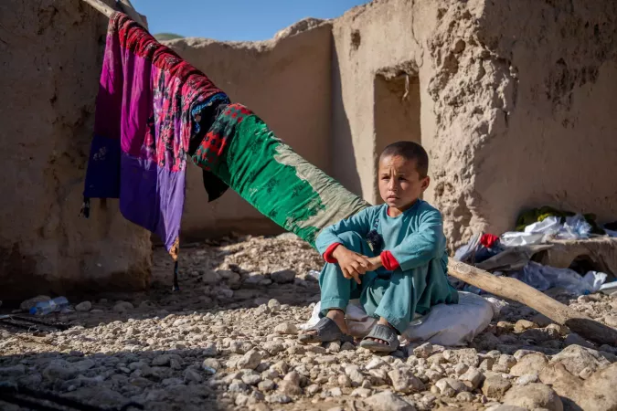 Un ni&ntilde;o sentada frente a su casa en ruinas en la provincia de Baghlan, Afganist&aacute;n. 