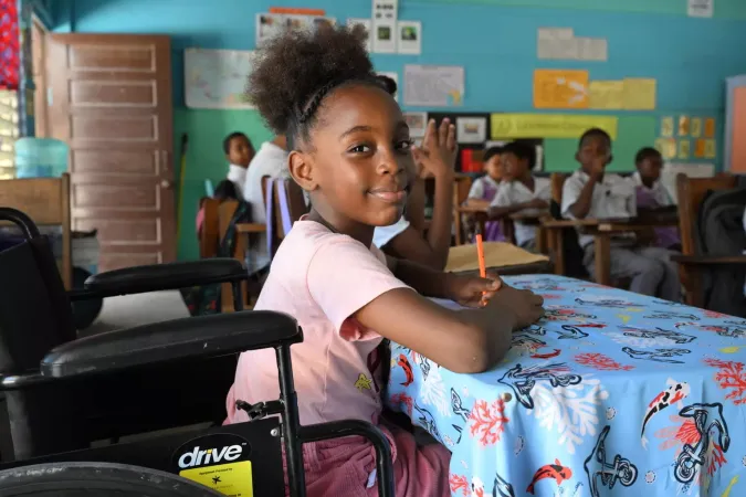 Una ni&ntilde;a en una silla de ruedas en el sal&oacute;n de clases
