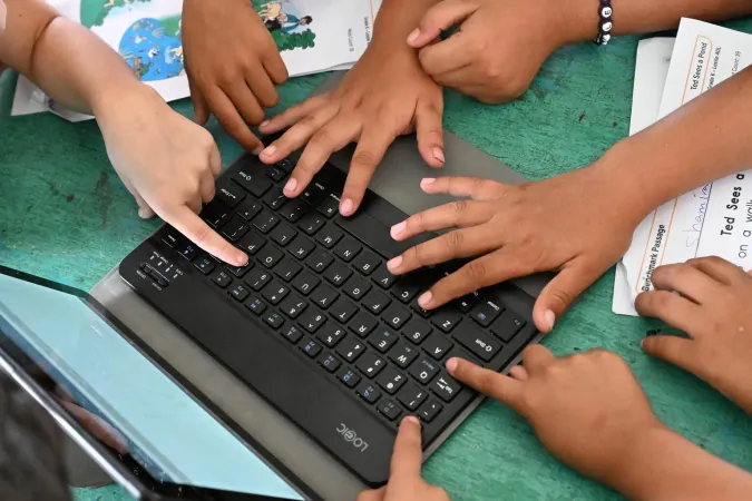 Manos de ni&ntilde;os sobre un computador