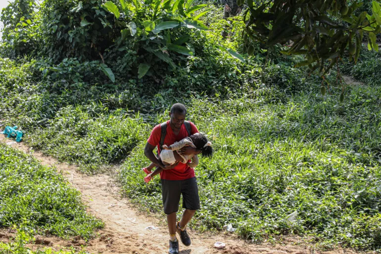 Father and child arrive exhausted after crossing the Darien Gap to Bajo Chiquito, Province of Darien, Panama, on 25 March 2020.