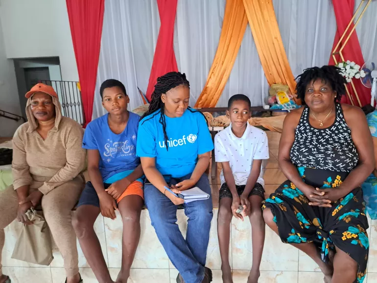 A child with family members and UNICEF personnel after the hurricane