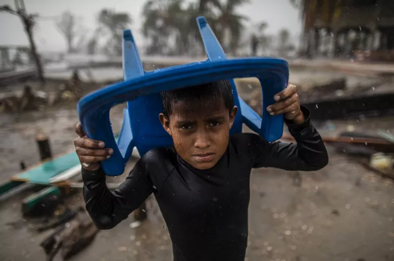 Un ni&ntilde;o se protege de la fuerte lluvia