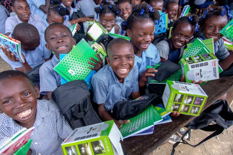Un group of children receive school supplies. 