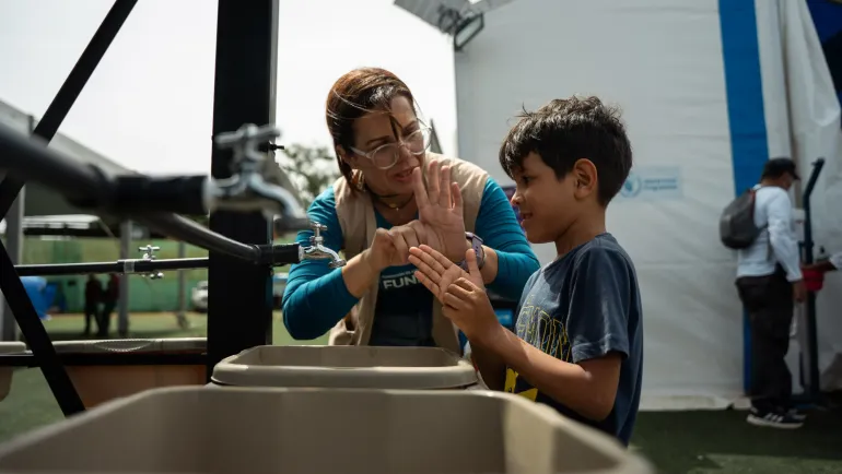 Ni&ntilde;o aprendiendo a lavarse las manos correctamente con personal de UNICEF