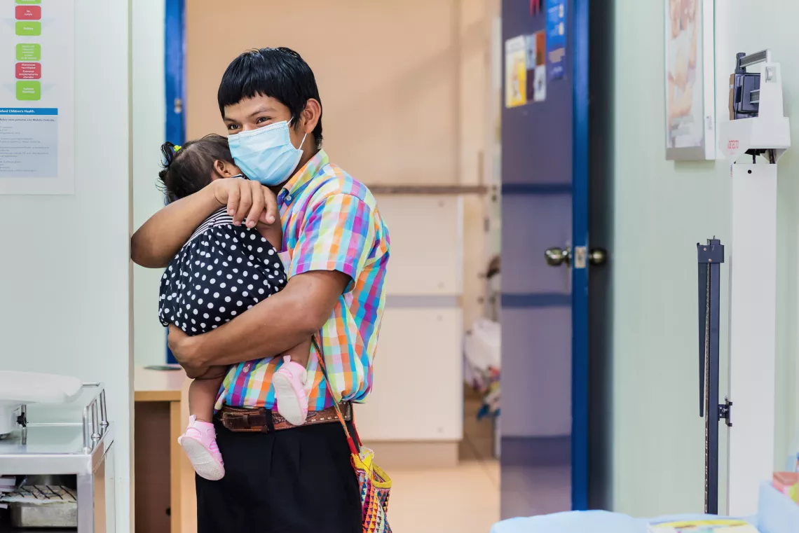 Padre ng&ouml;be carga a su beb&eacute; durante una visita de rutina al pediatra.