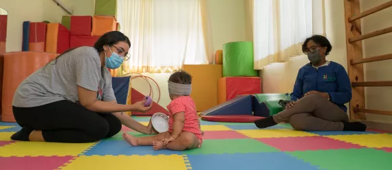 Santo Domingo, Dominican Republic, June 2021. A mother plays with her baby. Dr. Lourdes Perez counsels the family on Care for Child Development (CCD), a programme implemented by UNICEF in Latin America and the Caribbean.