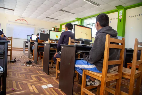 Grupo de estudiantes en un sal&oacute;n utilizando computadoras 