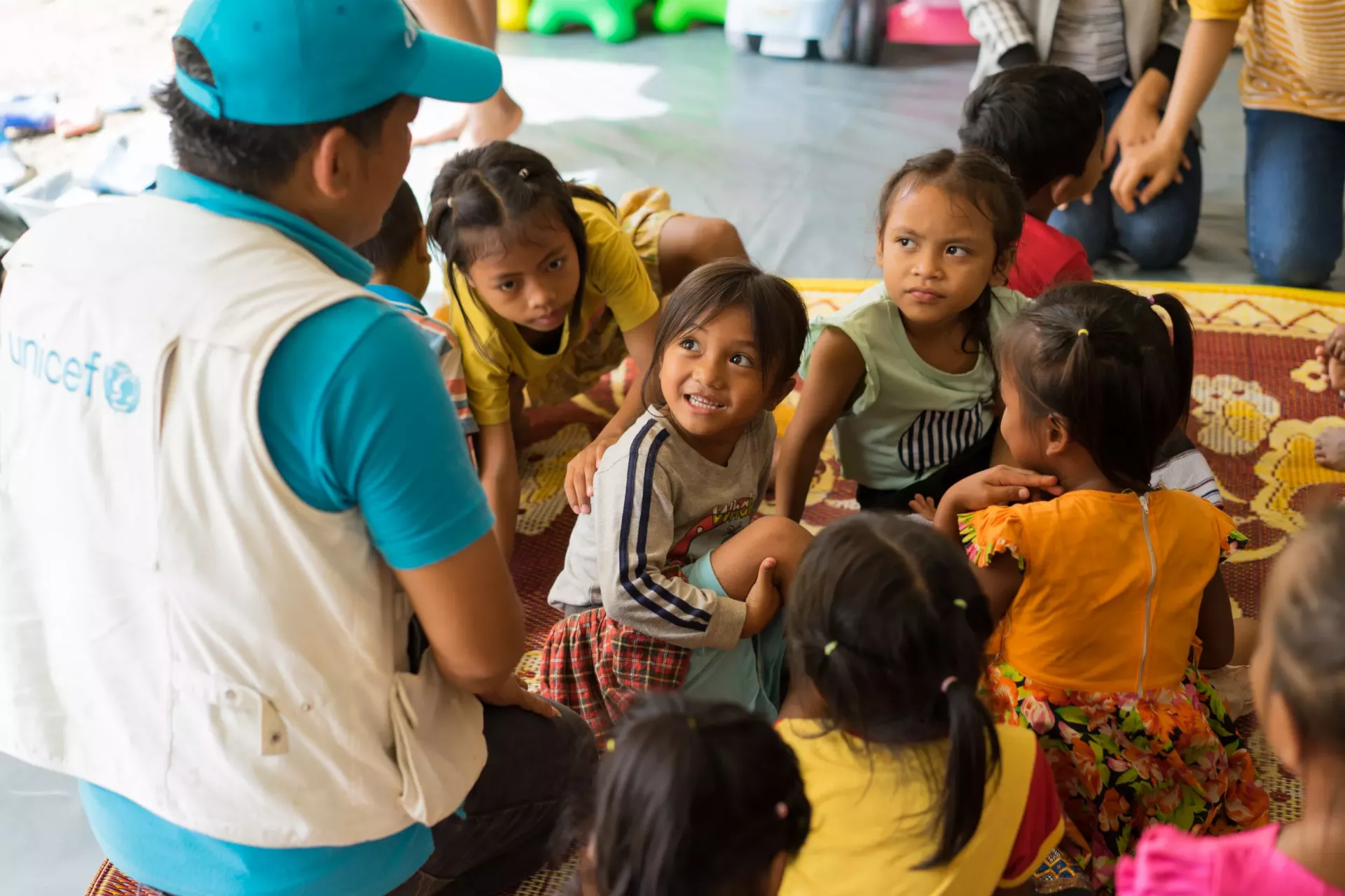 A UNICEF Laos staff member talks to children affected by the recent floods in Lao PDR inside a child friendly space in Ban Bok camp, Attapeu.   On 23 July 2018, a huge amount of water overflowed the construction site of Saddle Dam D of the Xepien- Xenamnoy hydropower dam, causing a flash flood through eight villages downstream in Attapeu. About 13,000 people have been affected by the floods and more than 4,270 are in emergency shelters, according to the ninth Situation Report issued by the United Nations.  