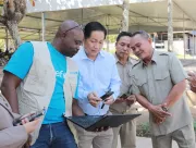 UNICEF staff and teachers gather to see data on the air quality sensors at the school.