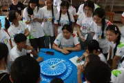 Students gather around a challenging word game, focusing on teamwork and problem-solving