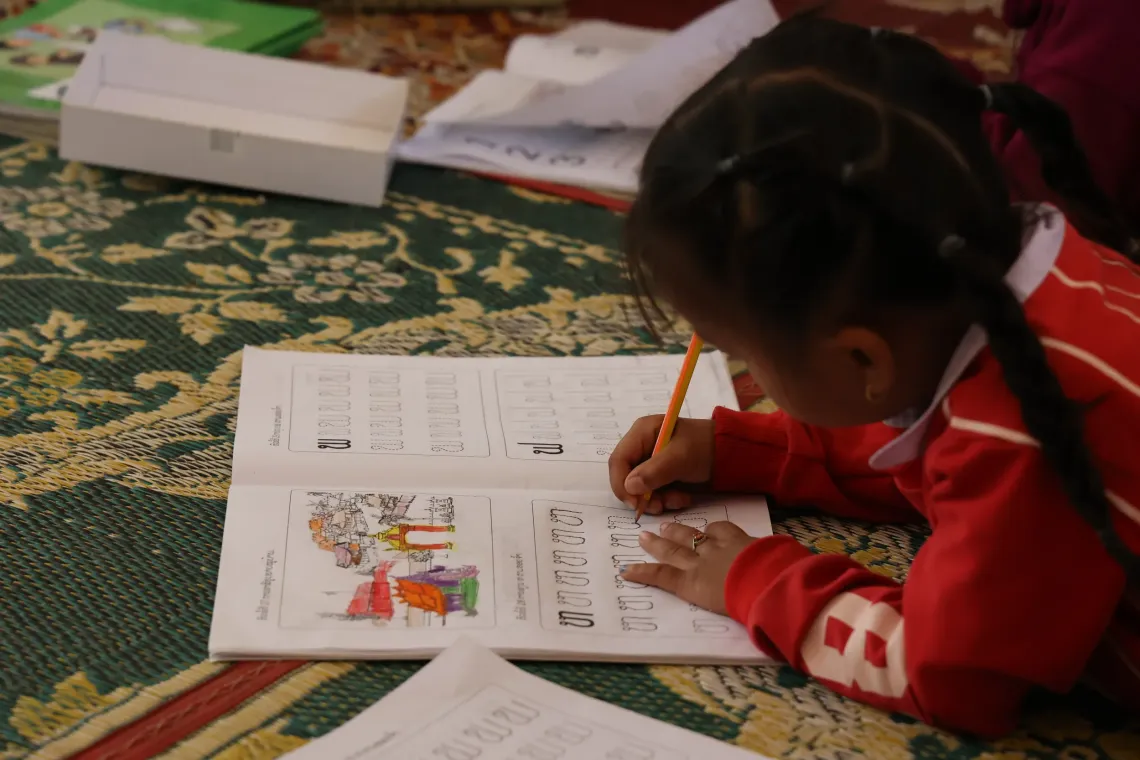 A child learns about Lao alphabets