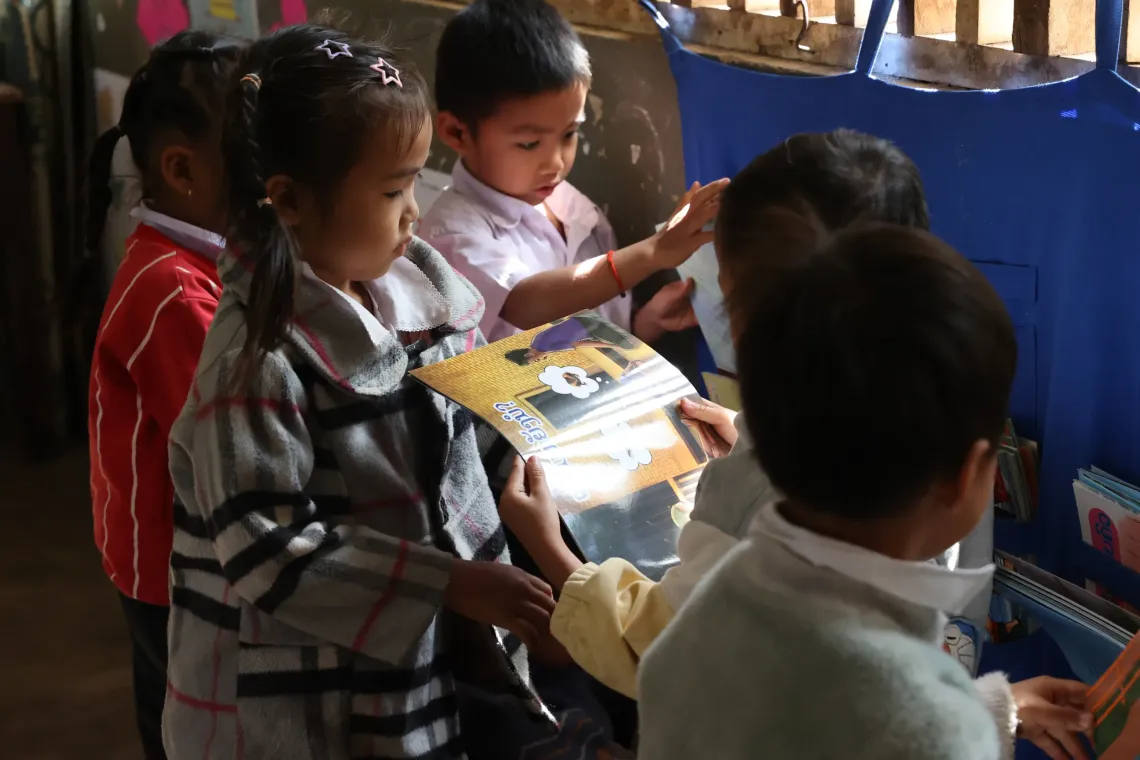 In the pre-primary class, children are exploring and picking books on their own. 