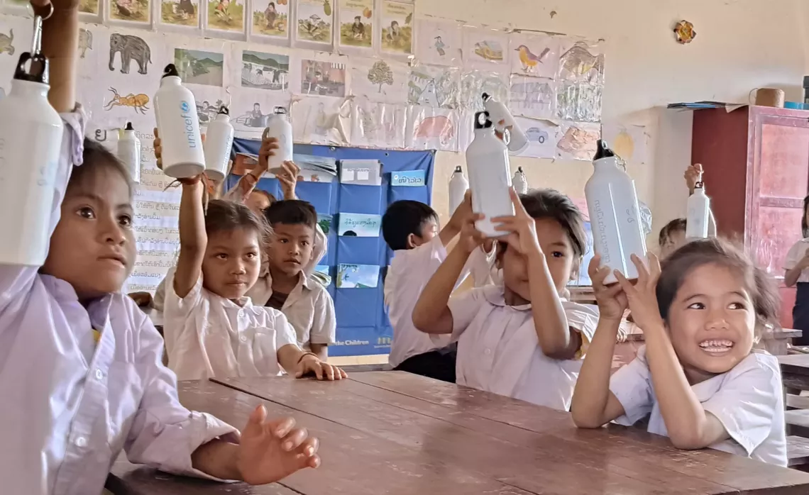 Children of Somsouk Primary School using their water bottles in the classroom.