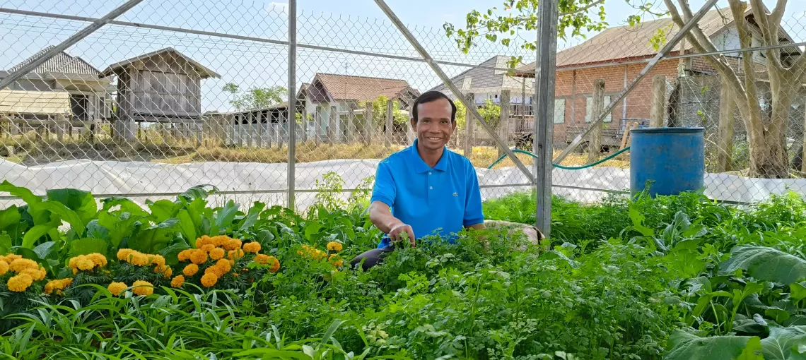 Thongdam tending to the vegetables grown in his schools&rsquo; greenhouse. 