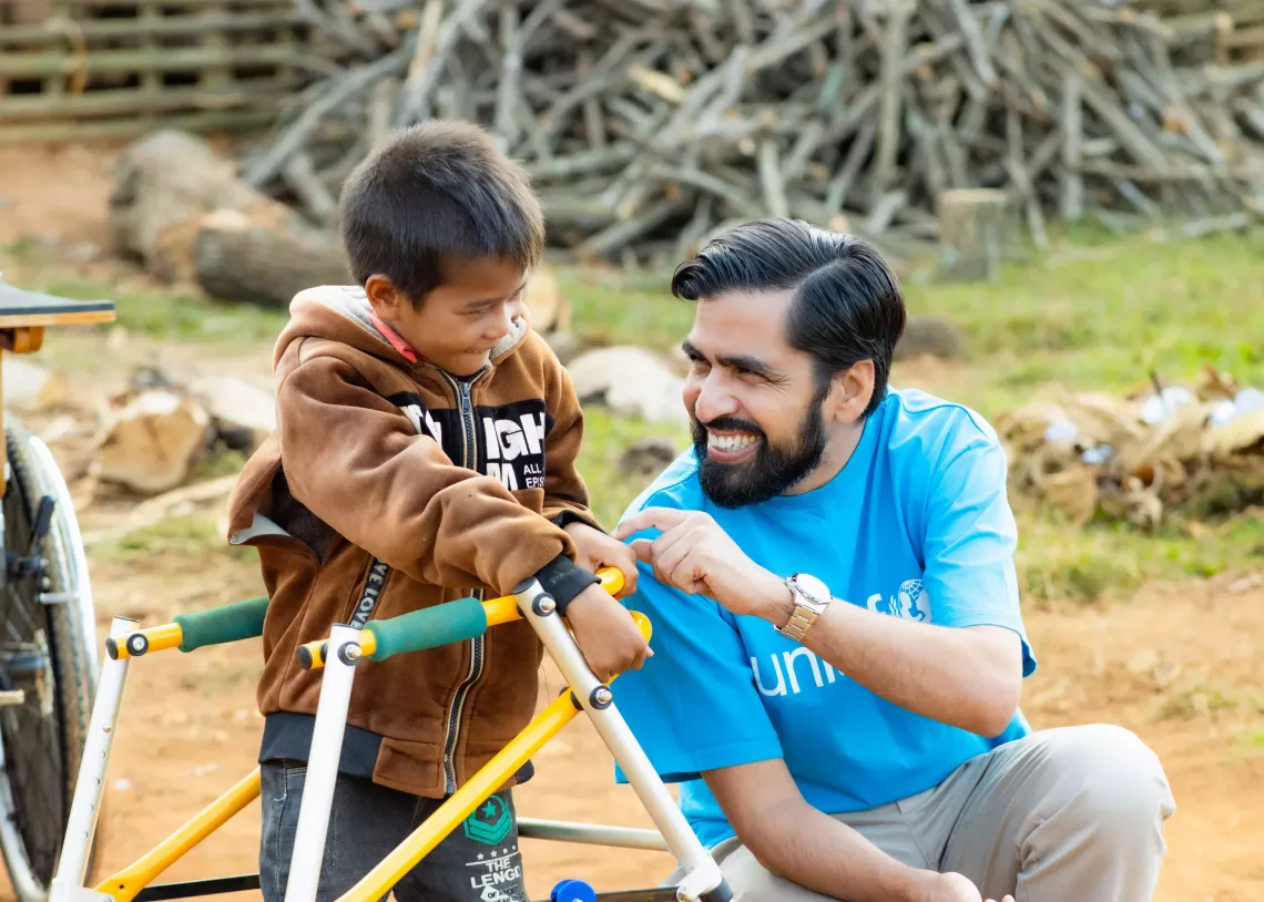Mr. Bilal Durrani, UNICEF Country Representative to Lao PDR, with a child who is receiving support from the Disability Grant Plus Initiative.