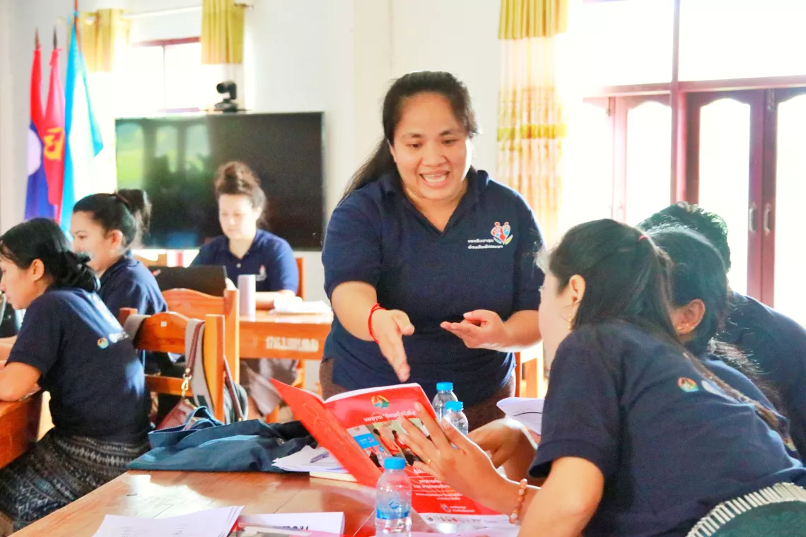 Tui confidently leads a discussion session on expanding the parenting program in Attapeu province, preparing these trainers to deliver sessions at the community level. 