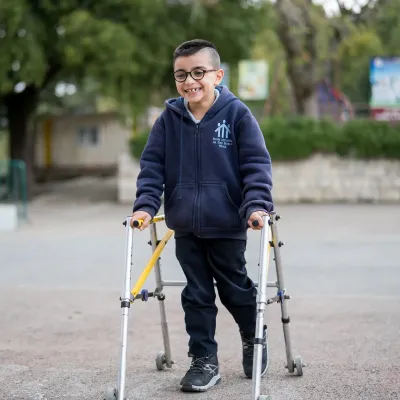 Elias, 8 years old walking around using a walker.
