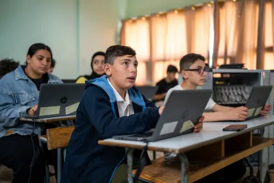 Abedelatif, 13 years old sitting in the classroom and using a laptop
