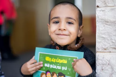 Child smiling while holding jad and tala story 