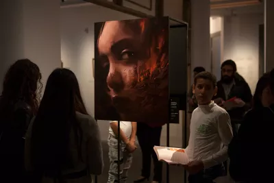 People during the exhibition contemplating the art work of a child 