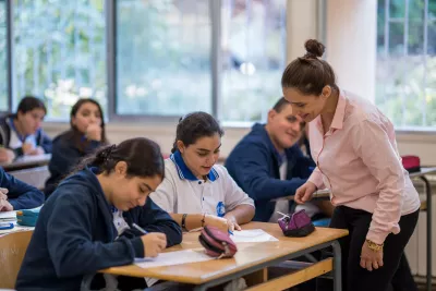 Teacher explaining to students inside a classroom 