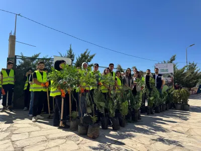 Youth standing behind the trees that they will be planting
