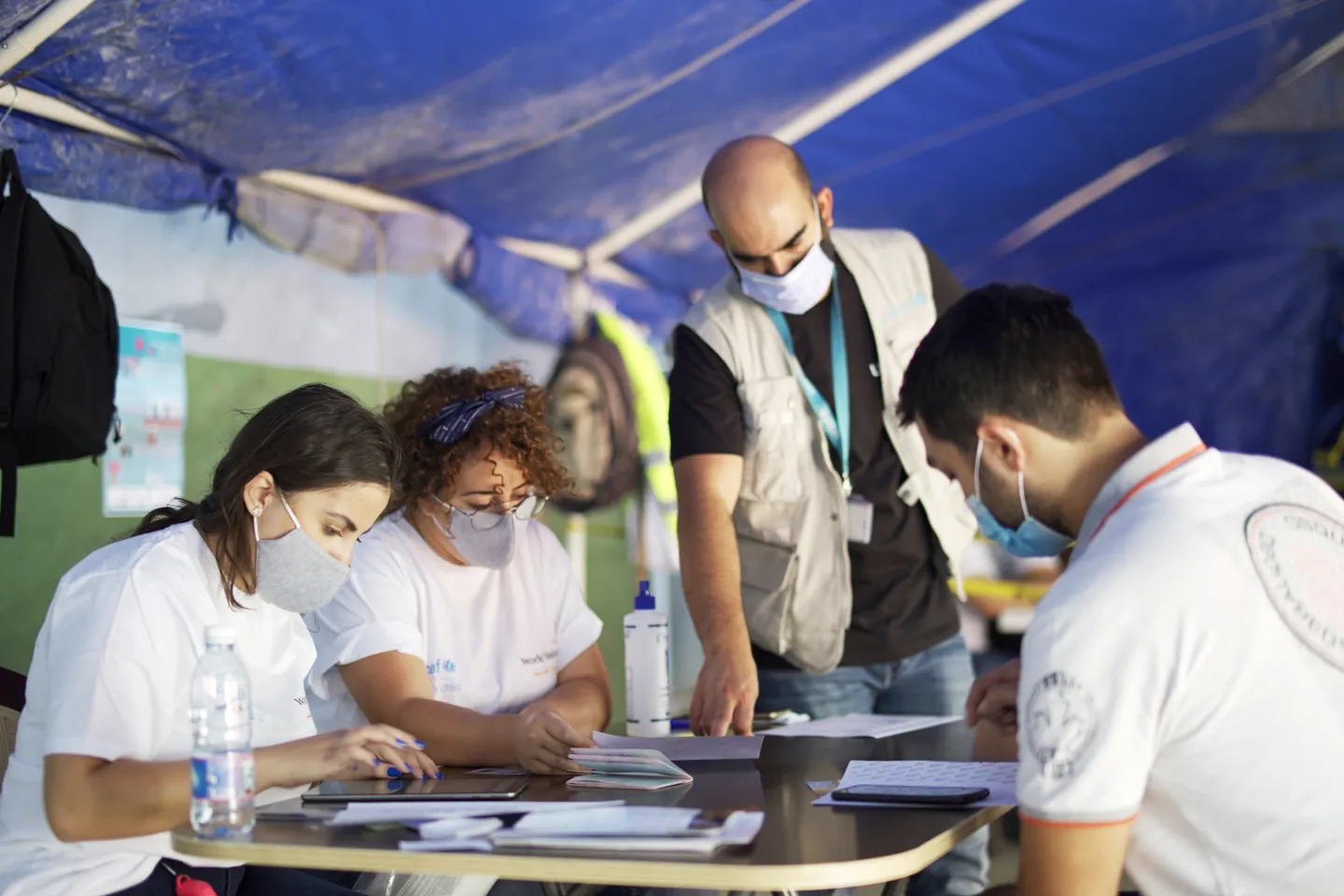 UNICEF staffer and world vision volunteers during the onsite registration of the emergency cash grant