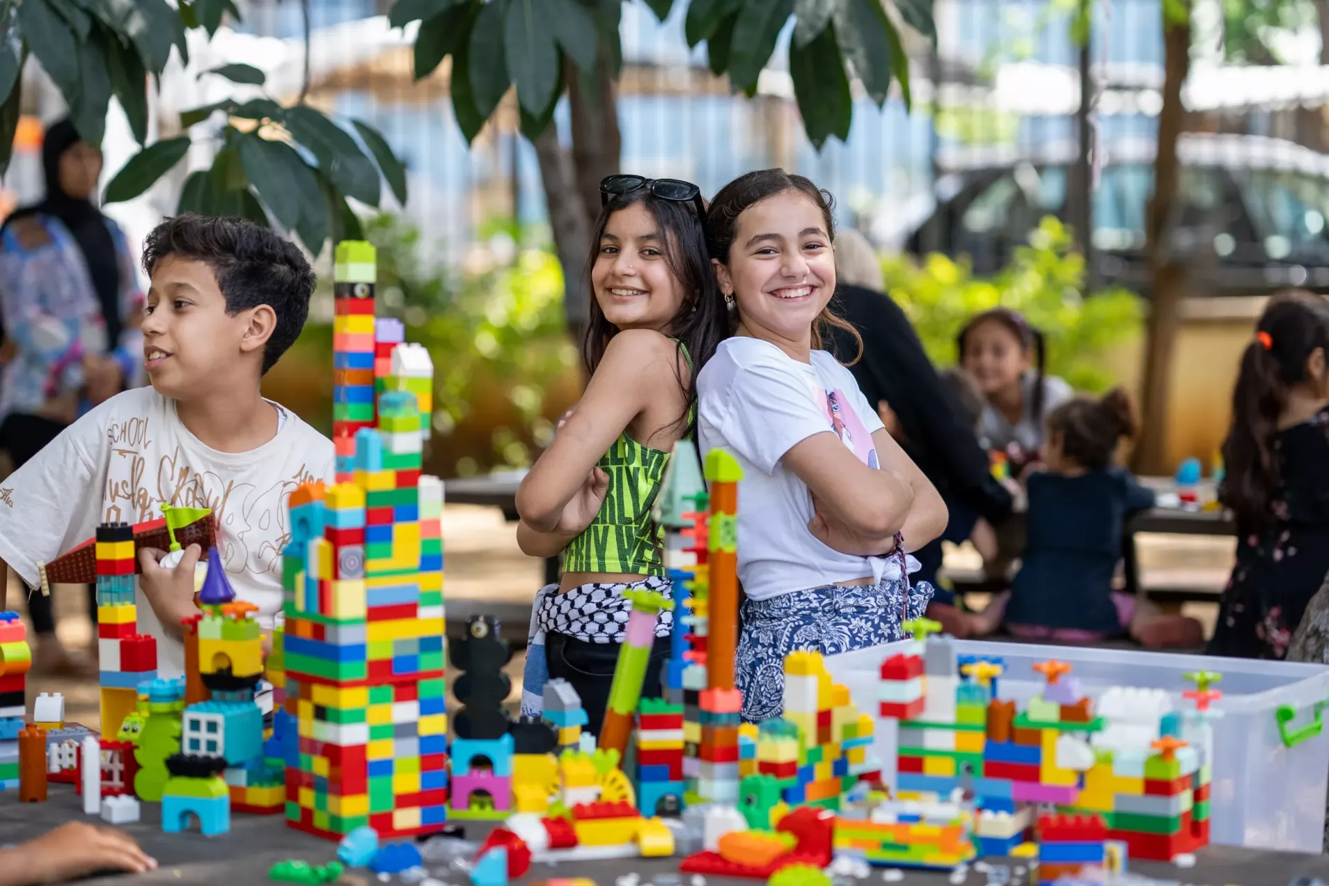 Fatima, 12 years old Tia, 12 years old, posing for the camera in front of the lego that they built 