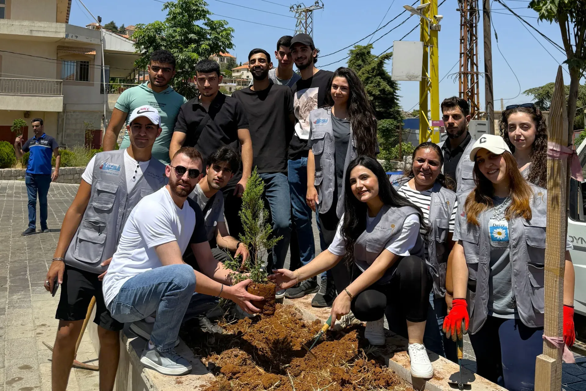 Youth during greener Lebanon event standing next to a tree that the will plant