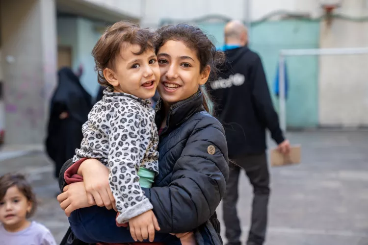 Hawraa, 3 years old with her sister Zeinab, 11 years old.