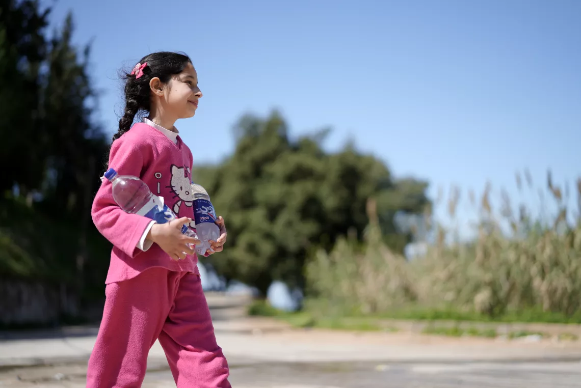 Syrine, 10 years transporting water bottles . 