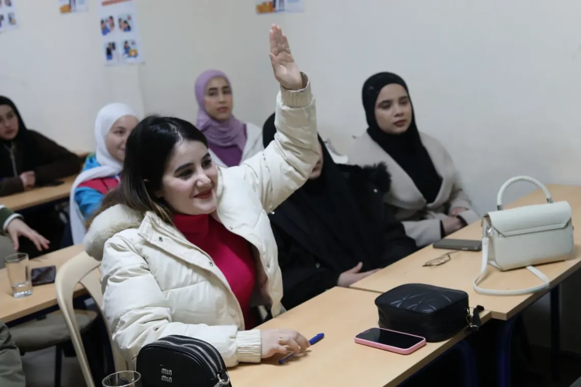 Fatima raising her hand in class 