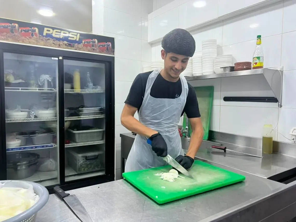 Mohamad Cutting onion in the kitchen