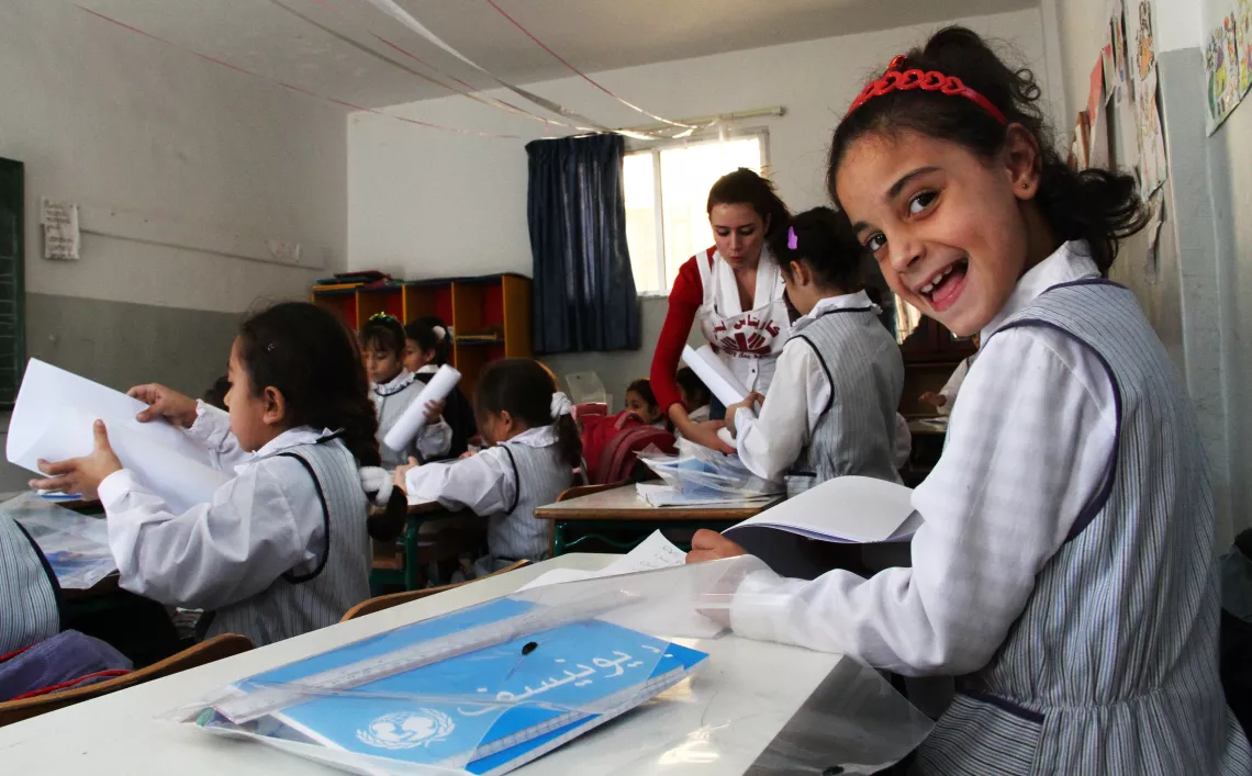 Syrian refugee and Lebanese students receive UNICEF educational supplies in Sidon, Lebanon. Because refugees are settling within poor Lebanese communities, emergency assistance reaches out to Syrian and Lebanese families alike.