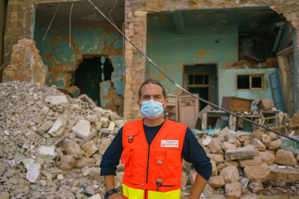 David Maisonneuve, standing in front of one if Beirut&rsquo;s directly hit and severely damaged buildings