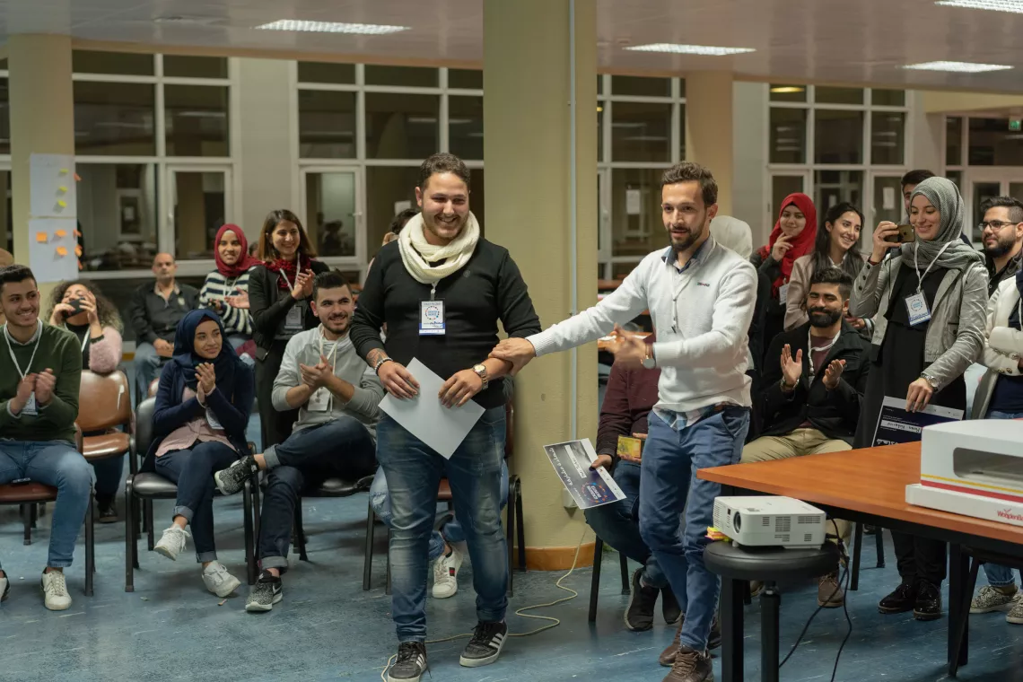 Hussein and Mahmoud joyfully present their ideas to their fellow youth. 