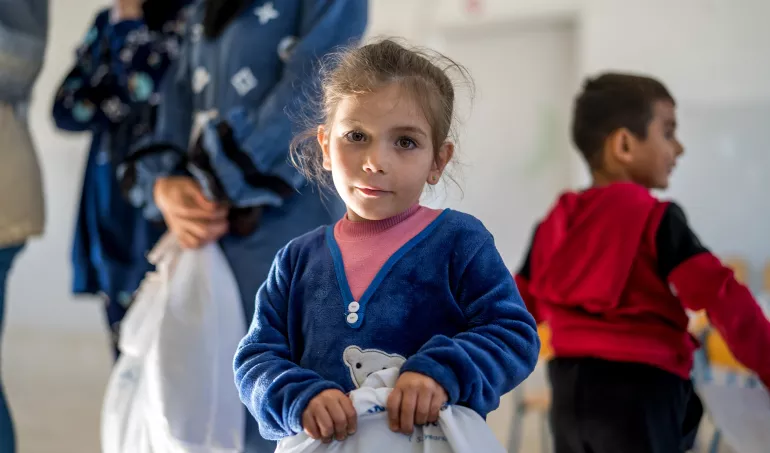 Aya, 4 years old holding a winter kit.
