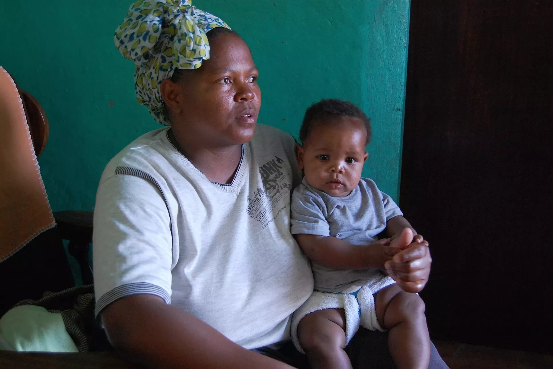 A mother sits with her baby on her lap