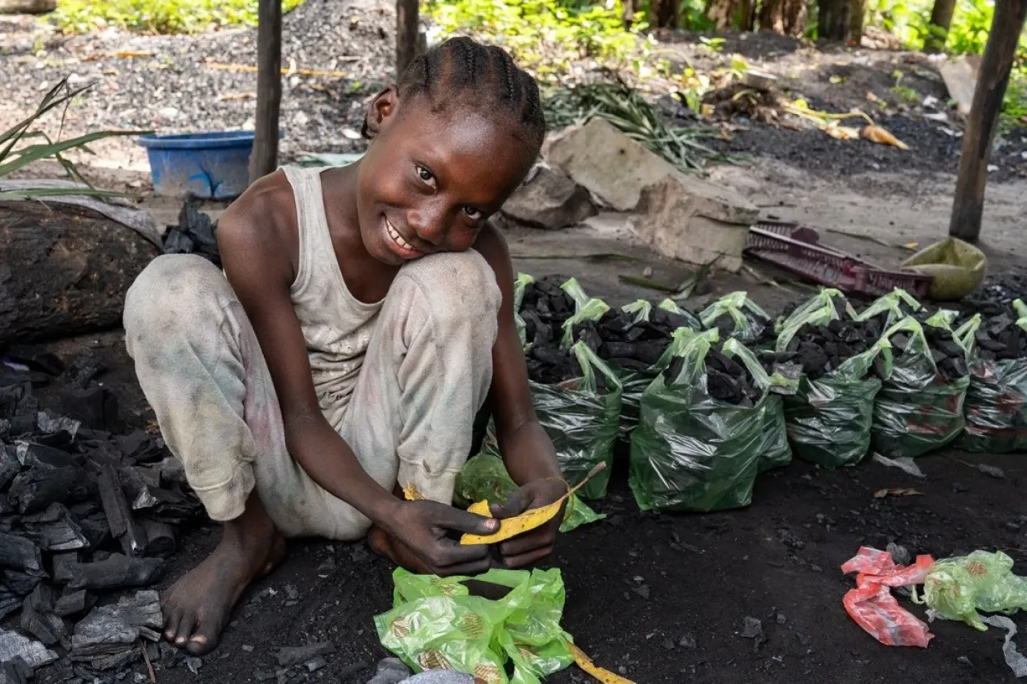 Fayor, age 14 helps pack the charcoal into bags. 