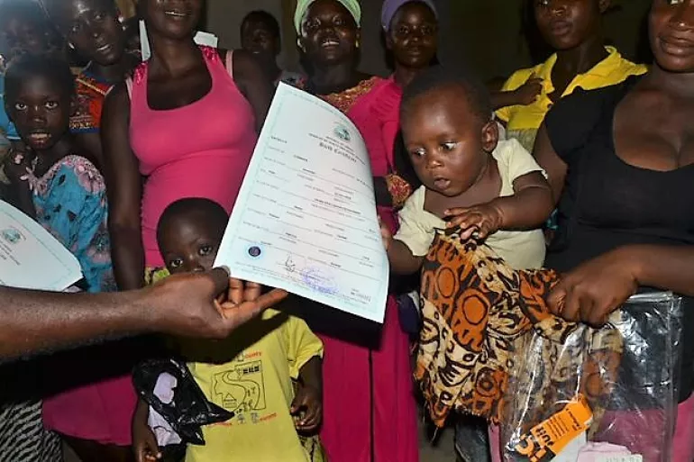 Child receiving birth certificate during a Birth Regristration Mobile Campaign in Wou Town Nimba county 