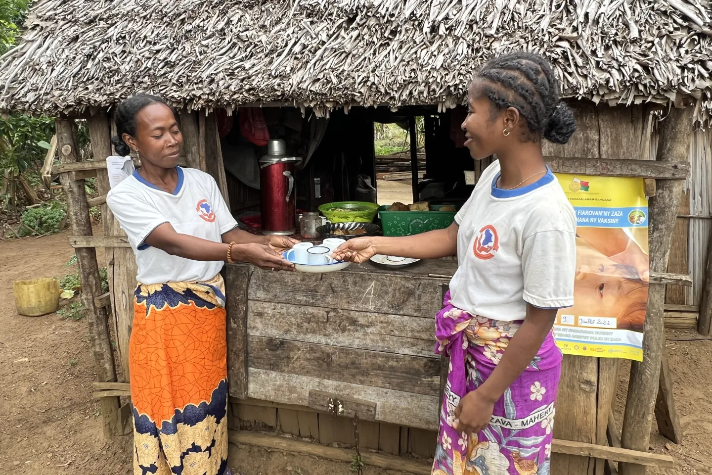 Mana (&agrave; gauche) se tient devant son magasin pour servir du caf&eacute; aux clients.