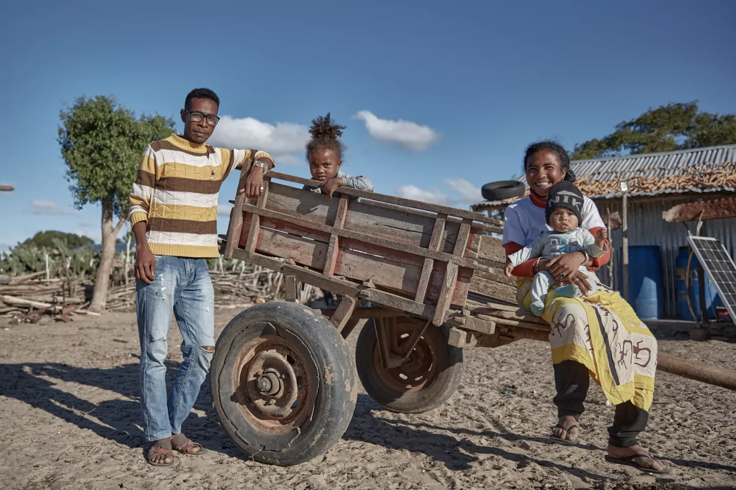Portrait de la famille Notsimbininiavo devant leur maison, accompagn&eacute;e de leur charrette.