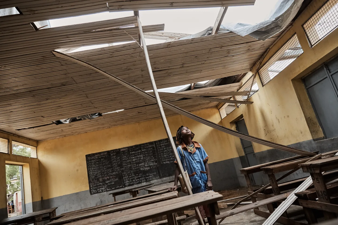 Une &eacute;l&egrave;ve du coll&egrave;ge d&rsquo;enseignement g&eacute;n&eacute;ral &agrave; Antananinarenina examinant le toit de sa salle de classe, arrach&eacute; par le cyclone Freddy en mars 2023.