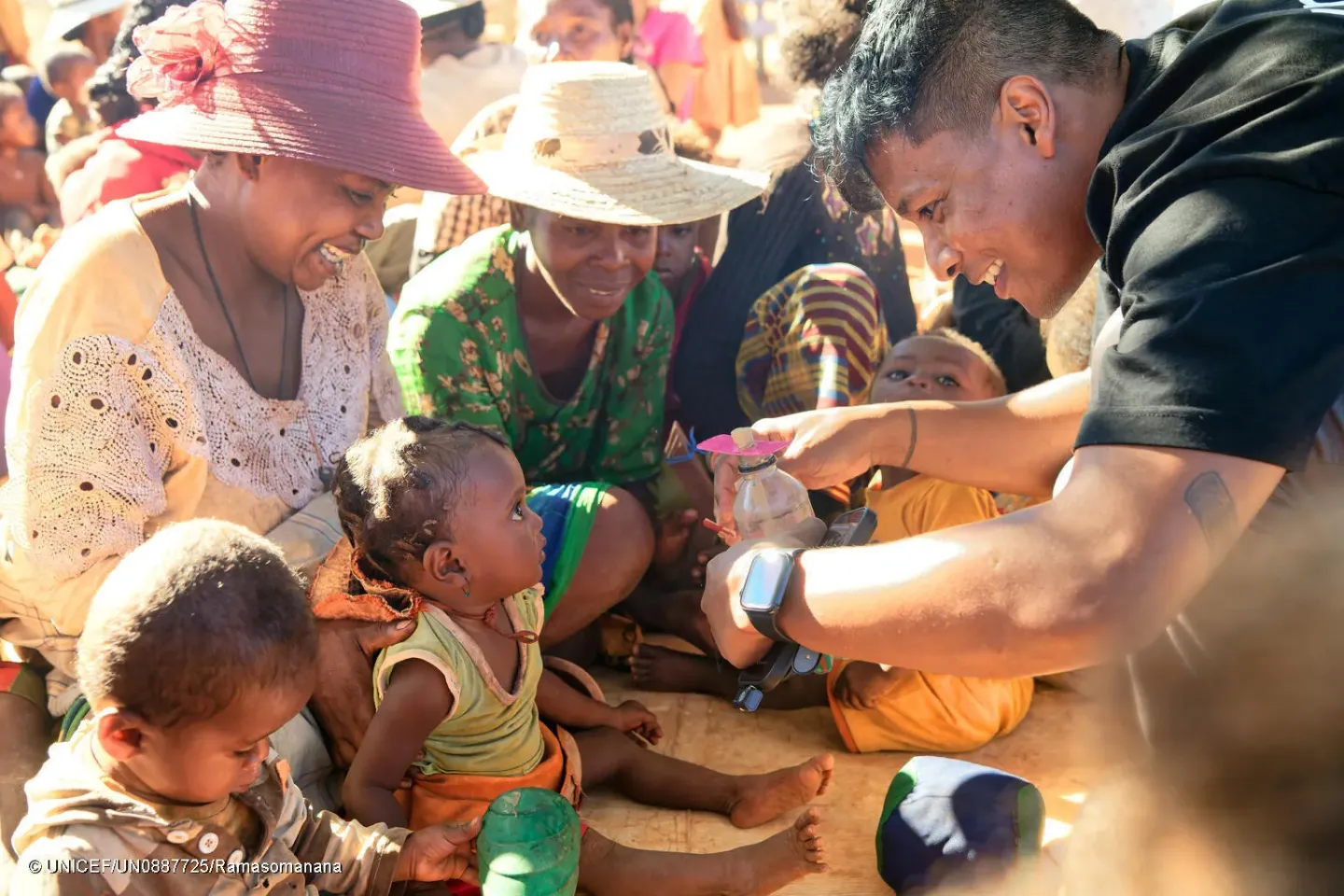 Mirado, Ambassadeur national de l&rsquo;UNICEF, montre &agrave; un enfant un jouet fabriqu&eacute; &agrave; partir d'une bouteille en plastique recycl&eacute;e.