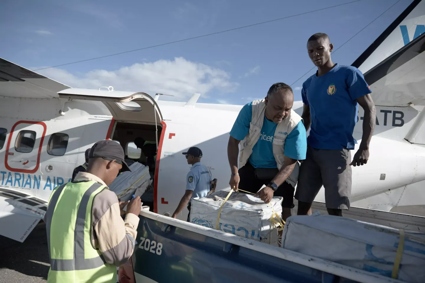 Josias Ratsimbazafy, sp&eacute;cialiste en &eacute;ducation &agrave; l&rsquo;UNICEF, charge les kits &eacute;ducatifs dans la voiture de la gendarmerie de Sambava, avant l&rsquo;acheminement vers les &eacute;coles. 