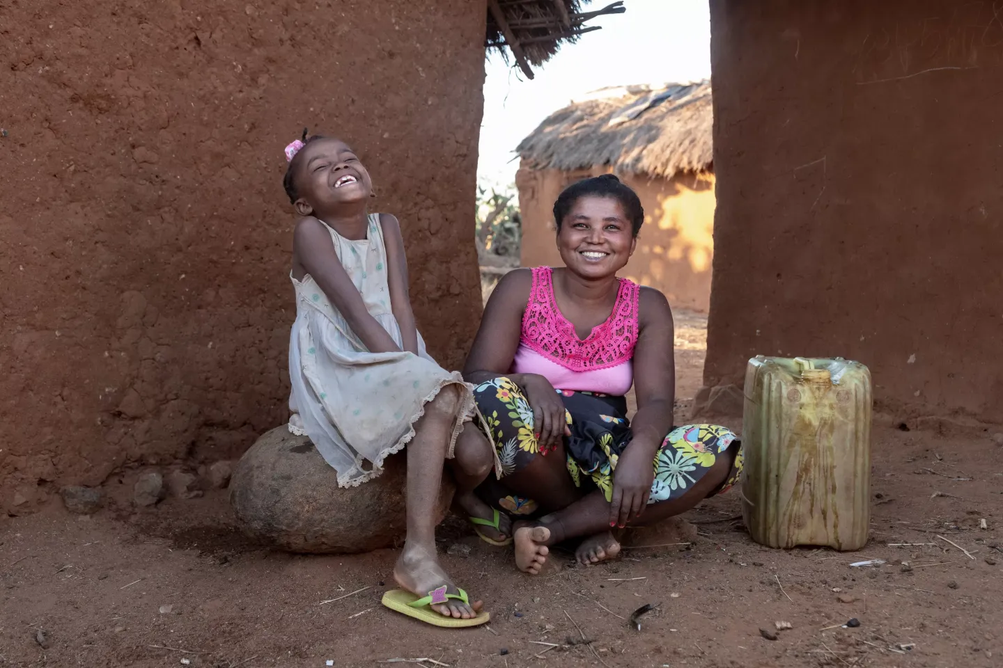 Variana, 29, a mother of four and a farmer, is seen with her daughter Deltine, 8, after fetching water from one of the newly installed water faucets. 